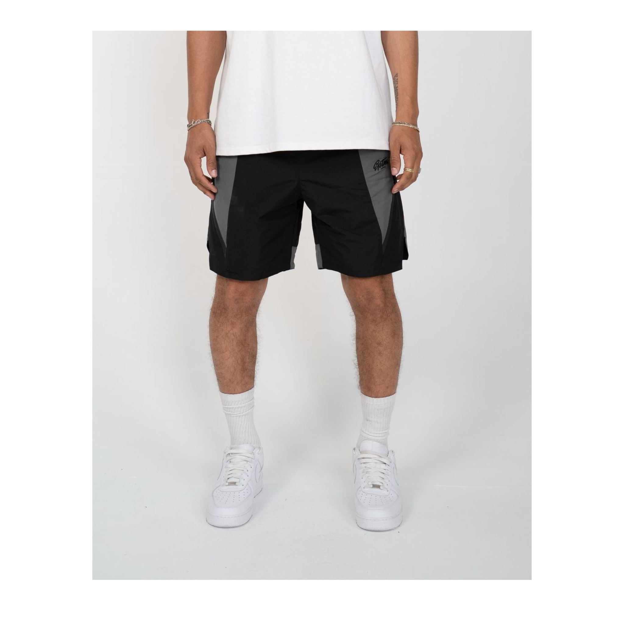 Person wearing black shorts with a white background